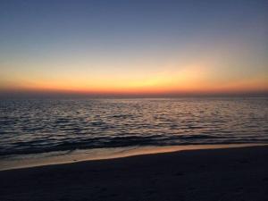 einen Sonnenuntergang über dem Meer am Strand in der Unterkunft Boddensurfer 2b Comfortable holiday residence in Pruchten