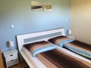 ein Schlafzimmer mit 2 Betten und einer blauen Wand in der Unterkunft Boddensurfer 2b Comfortable holiday residence in Pruchten
