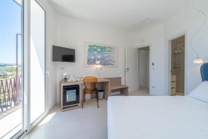 a bedroom with a bed and a desk with a television at Dimore delle Zagare Molo in Syracuse