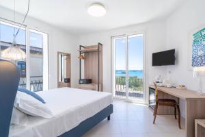 a bedroom with a bed and a desk with a computer at Dimore delle Zagare Molo in Syracuse