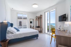 a bedroom with a bed and a desk with a television at Dimore delle Zagare Molo in Syracuse