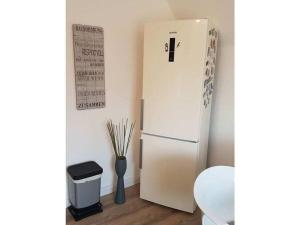 a white refrigerator in a room with a vase at FeWo Nero Comfortable holiday residence in Niebüll