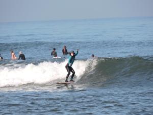 een persoon op een golf op een surfplank in de oceaan bij Ayolah surf House & Medewi Surf Camp in Jembrana