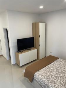 a bedroom with a bed and a flat screen tv at GlamByAJ with free parking and Netflix in Pula