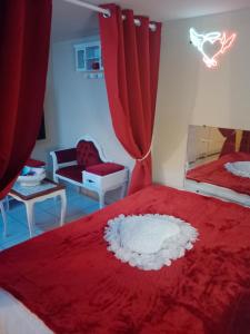 a bedroom with a red bed with a red curtain at Love Room Ange ou Démon à Aulnat in Aulnat