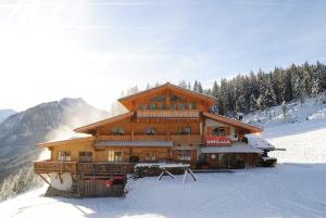 a large wooden building on a snow covered mountain at Winklalm in Flachau