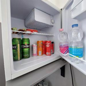 a refrigerator filled with drinks and soda bottles at Centerpoint Panzio Digital Pansion Heritage Collection in Budapest