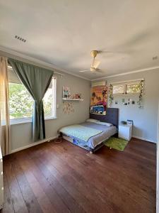 um quarto com uma cama e duas janelas em Chimu Home-Hostel em Perth