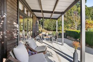 un patio con sedie e un tavolo su una casa di Supplejack Gardens a Upper Moutere