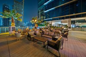 une terrasse avec des chaises et des tables dans un bâtiment dans l'établissement Park Regis Business Bay, à Dubaï