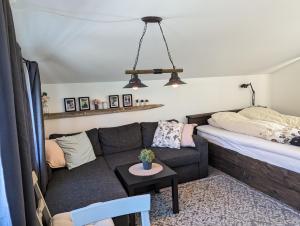 uma sala de estar com um sofá e uma cama em Midtbø Gard em Åna-Sira