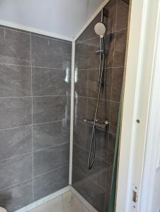 W łazience znajduje się prysznic ze szklanymi drzwiami. w obiekcie Midtbø Gard w mieście Åna-Sira