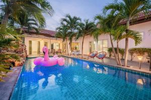 una piscina con un cisne rosado inflable en el medio en Majestic Residence Pool Villa 4 Bedrooms Private Beach en Pattaya South