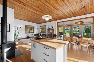 una cucina a pianta aperta e una sala da pranzo con soffitti in legno di Supplejack Gardens a Upper Moutere
