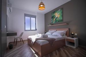a bedroom with a bed and a chair and a window at Modern Central Seaview Apartment Saranda in Sarandë