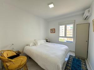 a bedroom with a bed and a chair and a window at Luxury Oceanfront Amazing view Playa del Acequion in Torrevieja