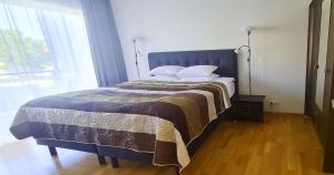una camera da letto con un letto con una coperta e una finestra di Seedri Residence a Pärnu