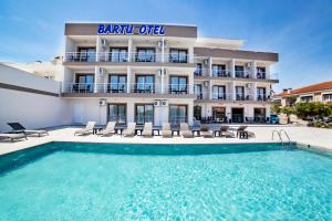 a hotel with a swimming pool in front of a building at Bartu Otel in Çeşme