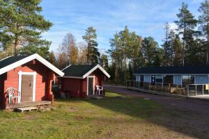um par de pequenos edifícios ao lado de uma estrada em Svinö Camping Lodge em Lumparland