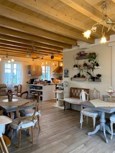 ein Wohnzimmer mit Holzdecken und Tischen sowie eine Küche in der Unterkunft ROSETO HOLIDAYS AZZURRO in Cavalcaselle