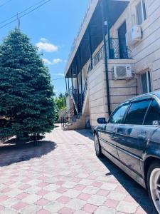 a car parked on a sidewalk next to a building at Вояж in Taraz +5 photos
