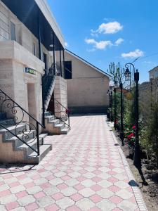 ceglany chodnik prowadzący do budynku ze schodami w obiekcie Вояж w mieście Taraz