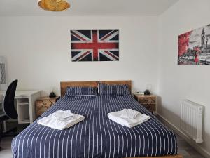 a bedroom with a bed with towels on it at Luxury 1-Bed Apartment with balcony & Free parking in Milton Keynes