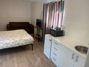 Dormitorio pequeño con cama y lavamanos en Blue Sapphire Village Pet Friendly, en Glen Innes