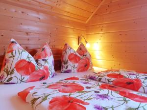 a bedroom with two beds with red flowers at Ferienhaus Lärchenhütte in Kasperle