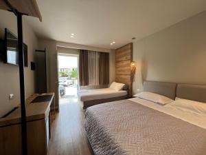 ein Hotelzimmer mit einem großen Bett und einem Sofa in der Unterkunft Sofo Hotel Dhermi in Dhërmi