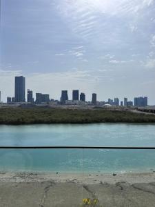 a view of a body of water with a city in the background at Enjoy Luxury Condo with Sea View in Abu Dhabi