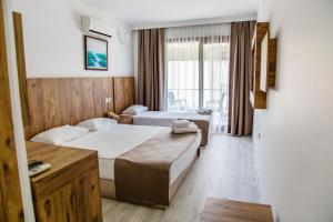 a hotel room with two beds and a window at Bartu Otel in Çeşme +25 photos