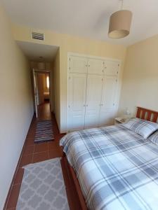 een slaapkamer met een bed met een blauw-witte deken bij Paola´s Costa Esuri, Albatros-Golf in Ayamonte