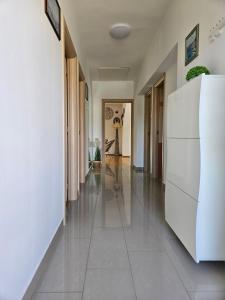 a hallway with white walls and a white refrigerator at Apartmani Pavlović in Krk