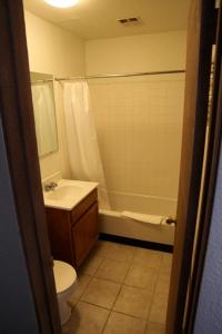 a bathroom with a toilet and a tub and a sink at Seatac Inn in SeaTac