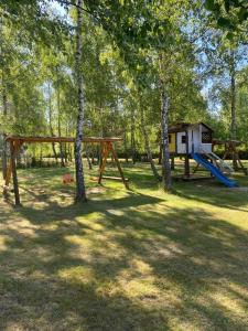 un parc avec une aire de jeux avec un toboggan dans l'établissement Domki Letniskowe Roztocze, à Zwierzyniec