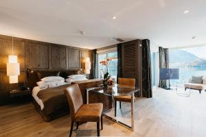 Schlafzimmer mit einem Bett und einem Glastisch in der Unterkunft BEATUS Wellness- & Spa-Hotel in Merligen
