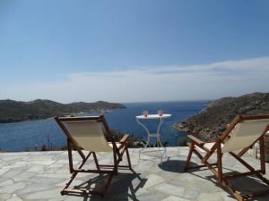 two chairs and a table with a view of the ocean at Gaia house, Ios Greece in Tzamaria