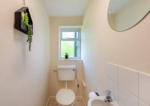 ein weißes Bad mit einem WC und einem Fenster in der Unterkunft Buckinghams Leary 