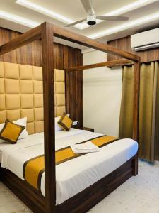 1 dormitorio con 1 cama con marco de madera en Airport Hotel Relax Inn, en Nagpur