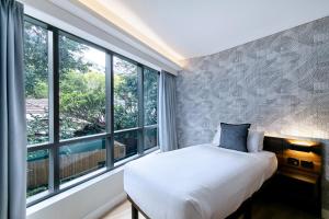 a bedroom with a bed and a large window at Kith Hotel Darling Harbour in Sydney