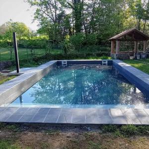 a swimming pool in a backyard with a gazebo at L'Antojana del Cuera Llanes Aptos in Covielles
