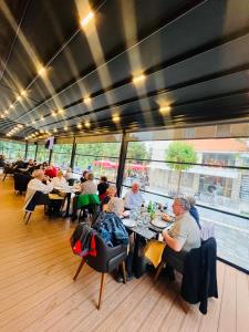 a group of people sitting at tables in a restaurant at Hotel & Restaurant White City in Berat