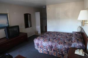 um quarto de hotel com uma cama e uma televisão em Seatac Inn em SeaTac