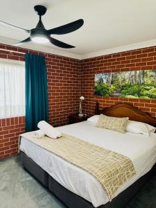 - une chambre avec un grand lit et un ventilateur de plafond dans l'établissement The Roseville Apartments, à Tamworth