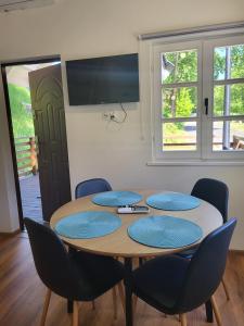 a wooden table with blue chairs and a television at Hotel i Camping Tramp in Toruń