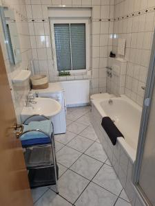 Wohnung in Oberhausen: zentral & ruhig, eigener Eingang في أوبرهاوزن: حمام أبيض مع حوض ومغسلة