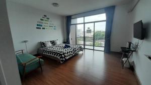 - une chambre avec un lit et une grande fenêtre dans l'établissement HOMEY-Don Mueang Airport Hostel, à Bangkok