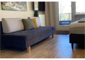 a blue couch in a living room with a window at Bavarian Escape Ferienwohnung mit Pool in Sankt Englmar +25 photos
