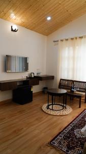 salon ze stołem i krzesłami w pokoju w obiekcie Saanjh Cottages w mieście Bir